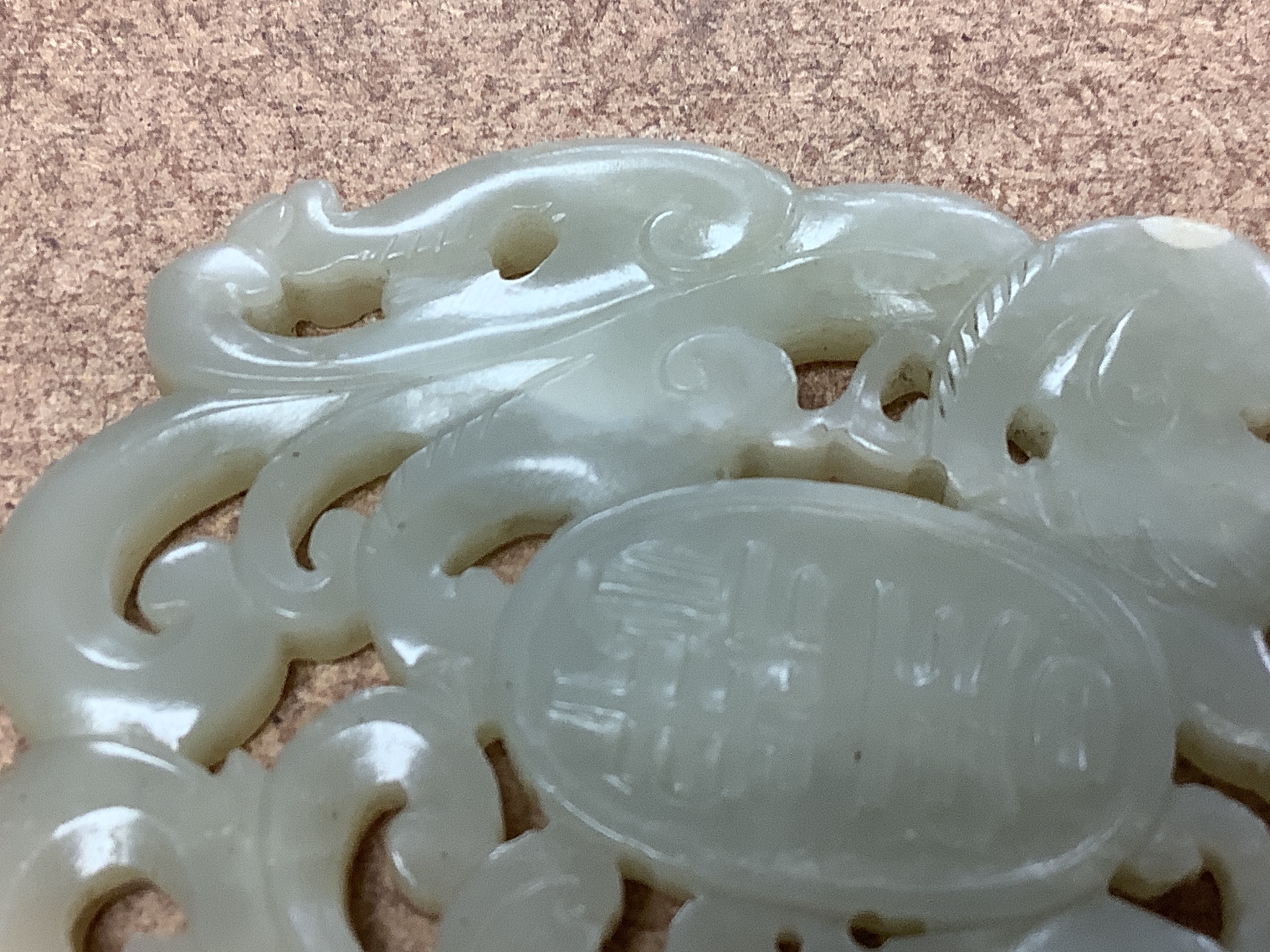 A Chinese yellow metal amounted jade pendant, 63mm, carved with dragons and character marks.